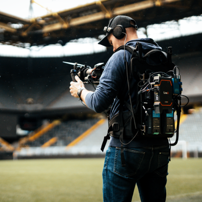 Kameraoperator mit Broadcast-Rucksack bei einer Livestream-Produktion